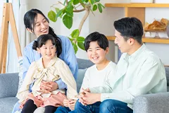 四人家族がソファに座って歓談している