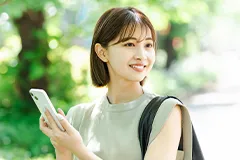 スマートフォンを持った女性が周囲を見渡している