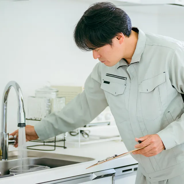 蛇口の水が出るかを確認している作業員